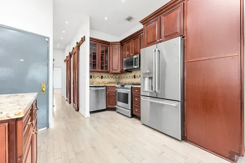 a kitchen with stainless steel appliances granite countertop a refrigerator a stove a sink and a refrigerator