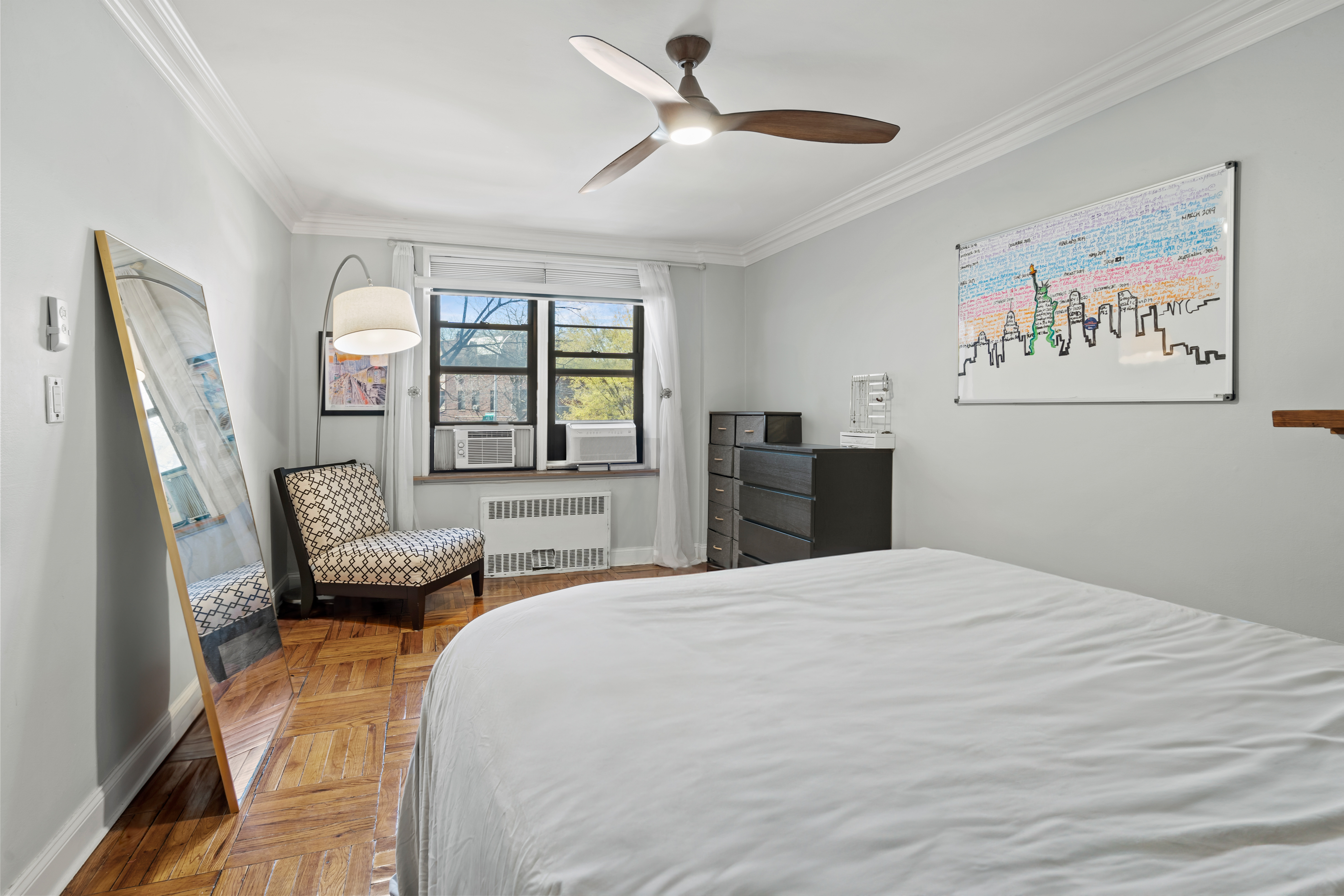 48-21 40th Street, Unit 1B Queens, NY 11104 - Photo 6 of 9 a bedroom with a bed couch and a window