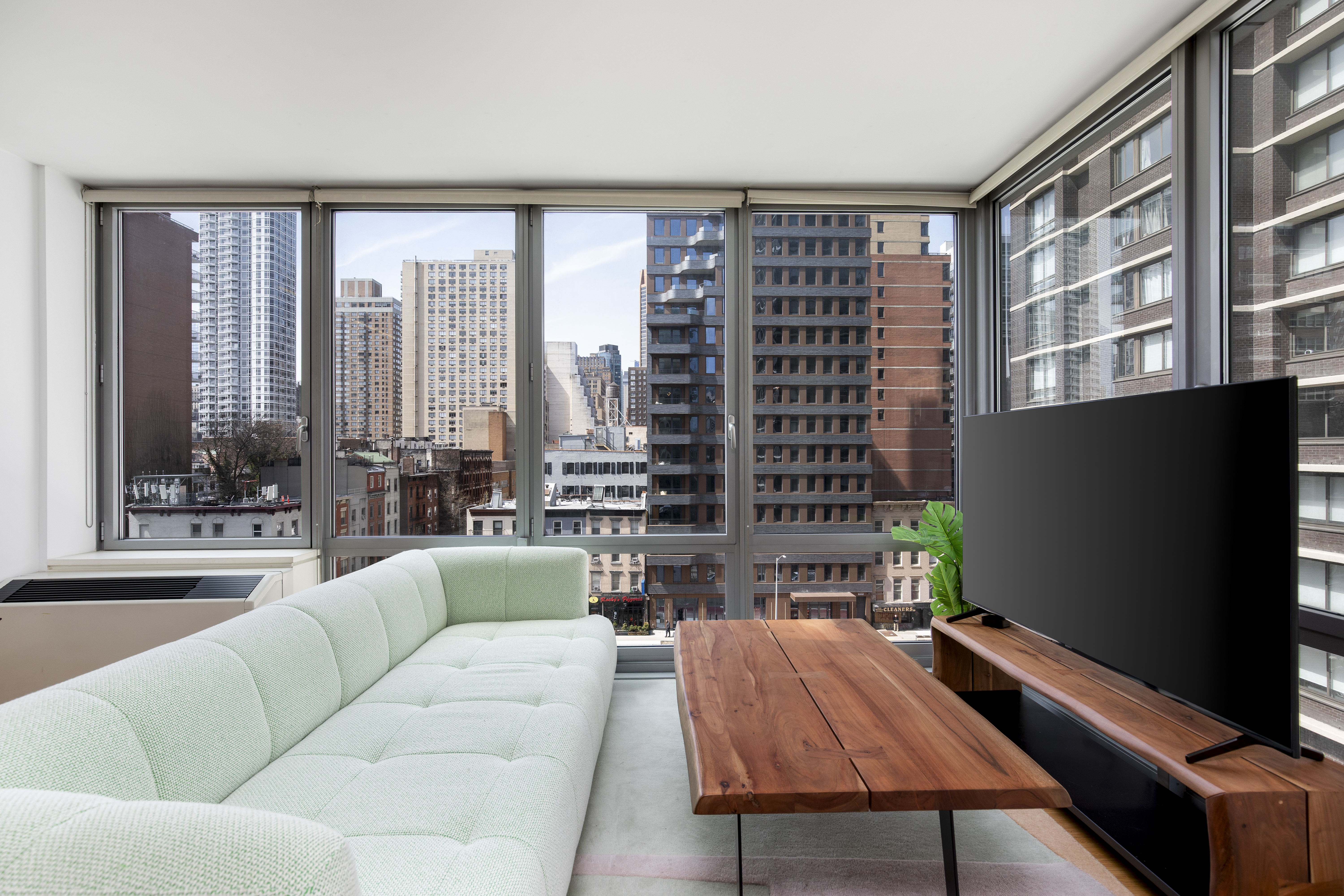303 East 33rd Street, Unit 7N Manhattan, NY 10016 - Photo 3 of 12 a living room with furniture and a flat screen tv