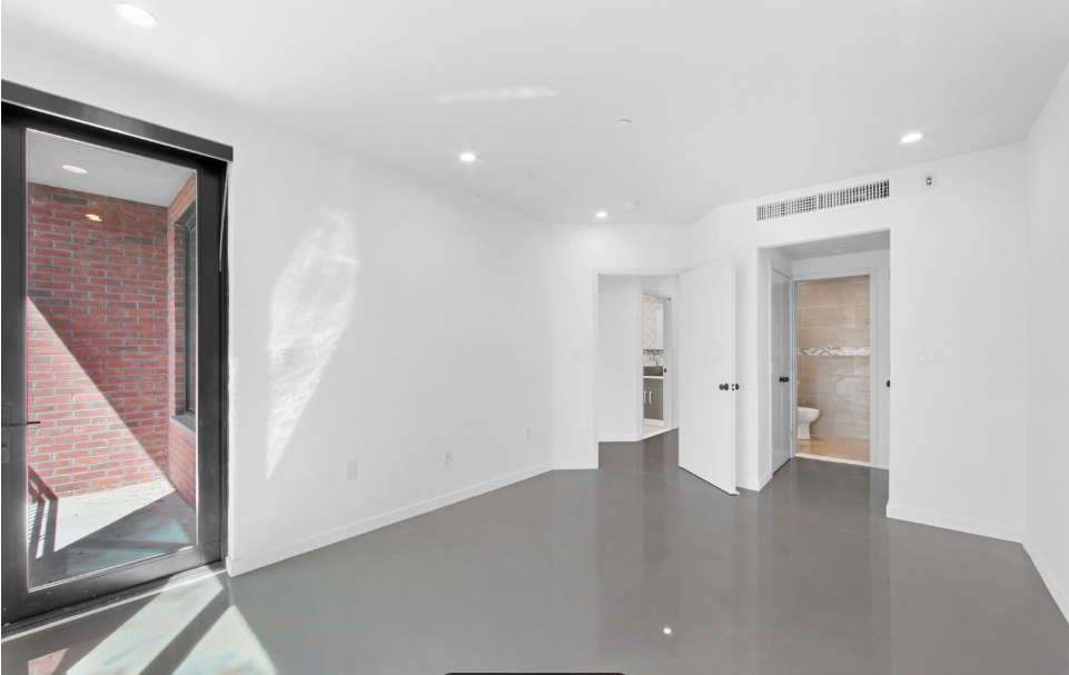 278 Warren Street, Unit 4 Brooklyn, NY 11201 - Photo 4 of 8 a view of an empty room with wooden floor and a bathroom