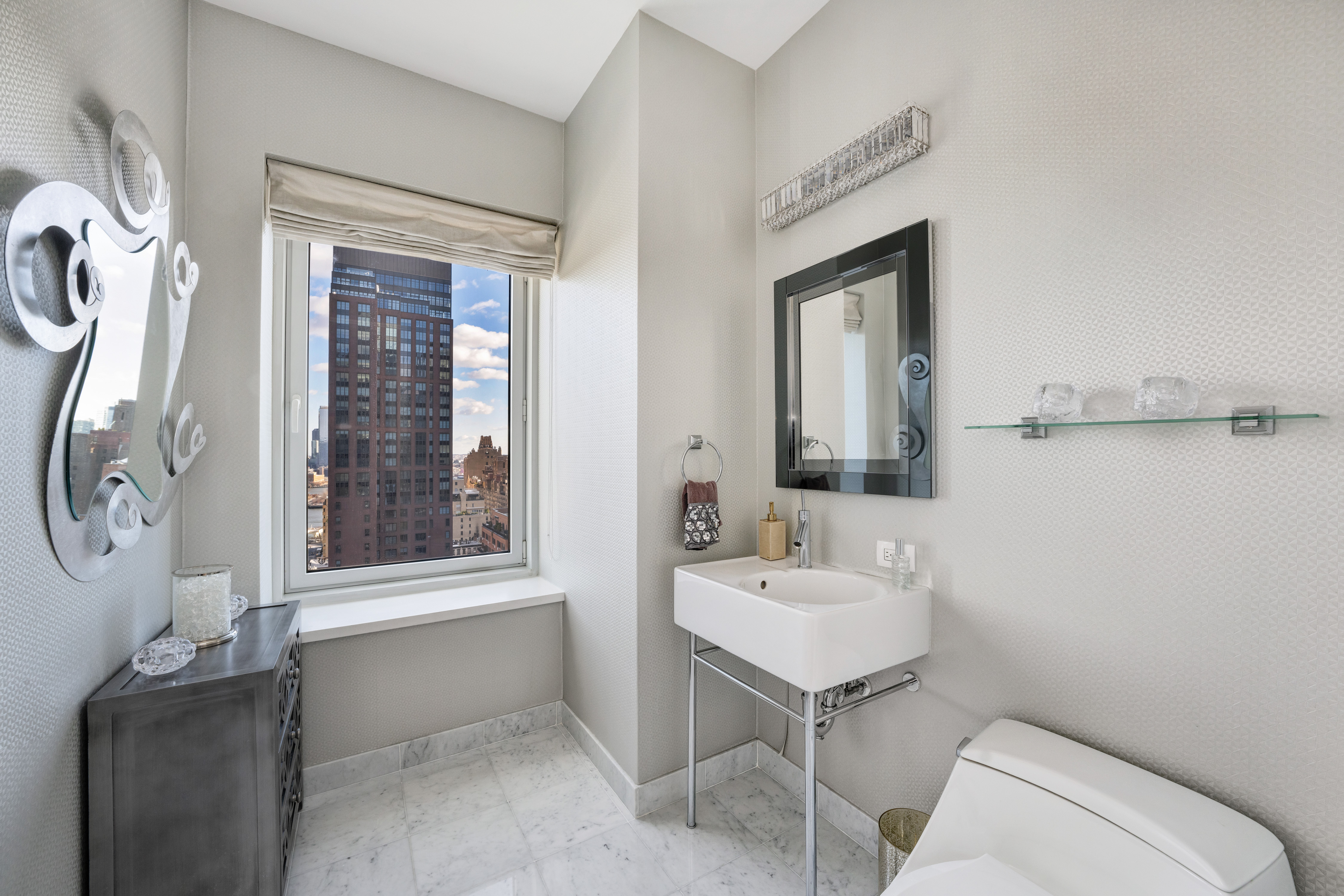310 East 53rd Street, Unit 18A Manhattan, NY 10022 - Photo 7 of 19 a bathroom with a toilet sink and mirror
