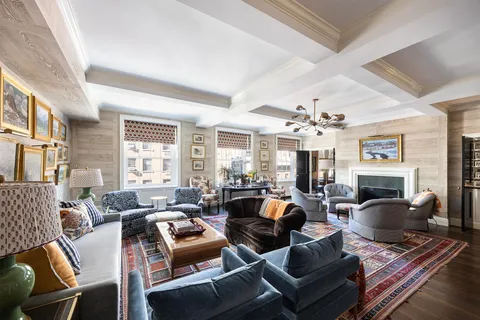 a living room with furniture fireplace and a large window