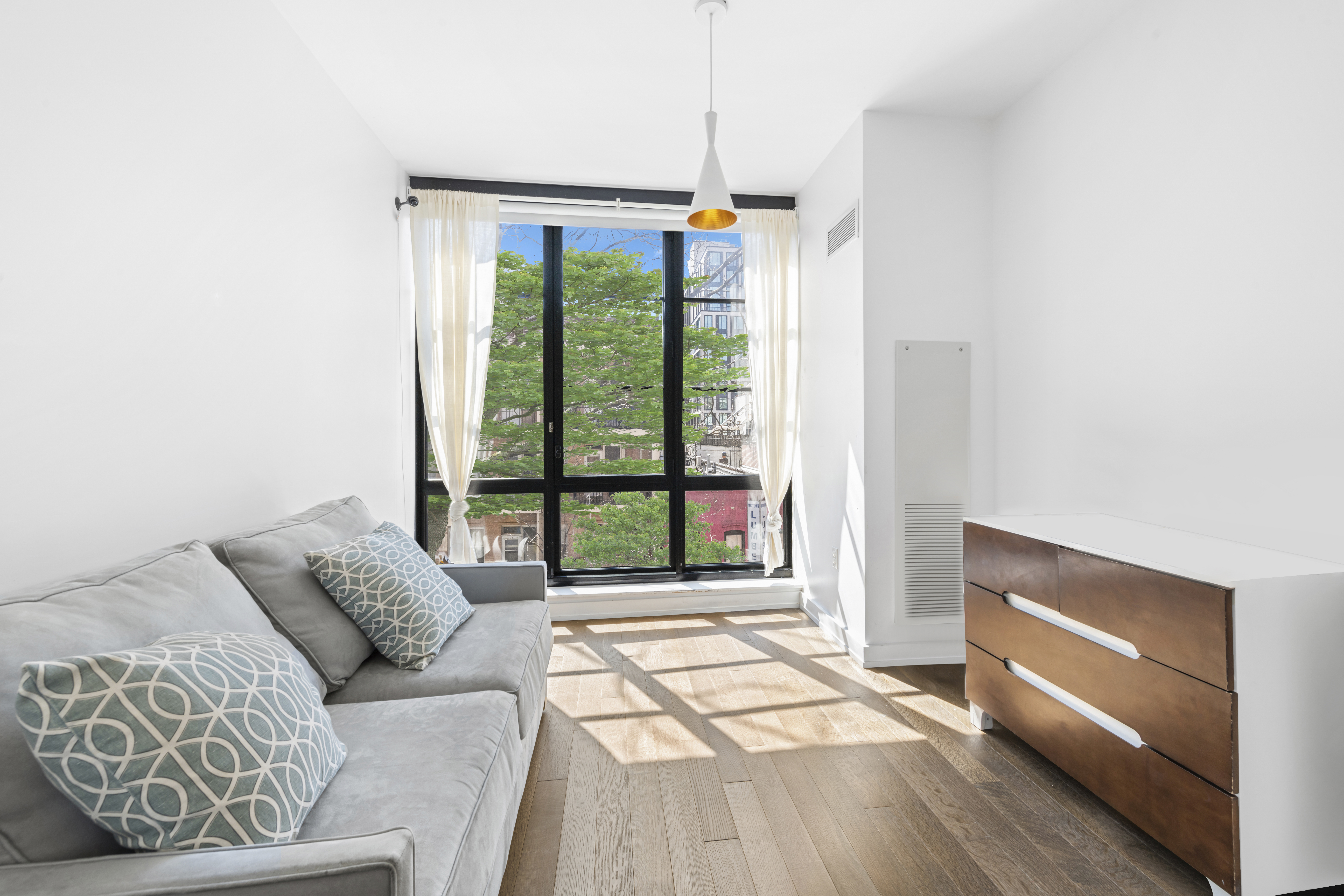 261 West 25th Street, Unit 4D Manhattan, NY 10001 - Photo 10 of 14 a living room with furniture and a flat screen tv