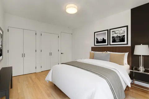 a spacious bedroom with a bed and a lamp on table