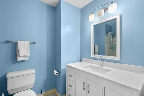 a bathroom with a toilet sink and mirror