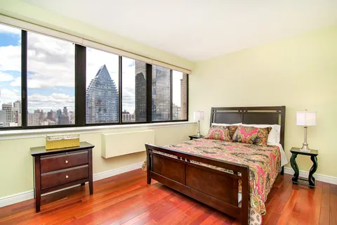 a bedroom with a bed and a large window with outer view