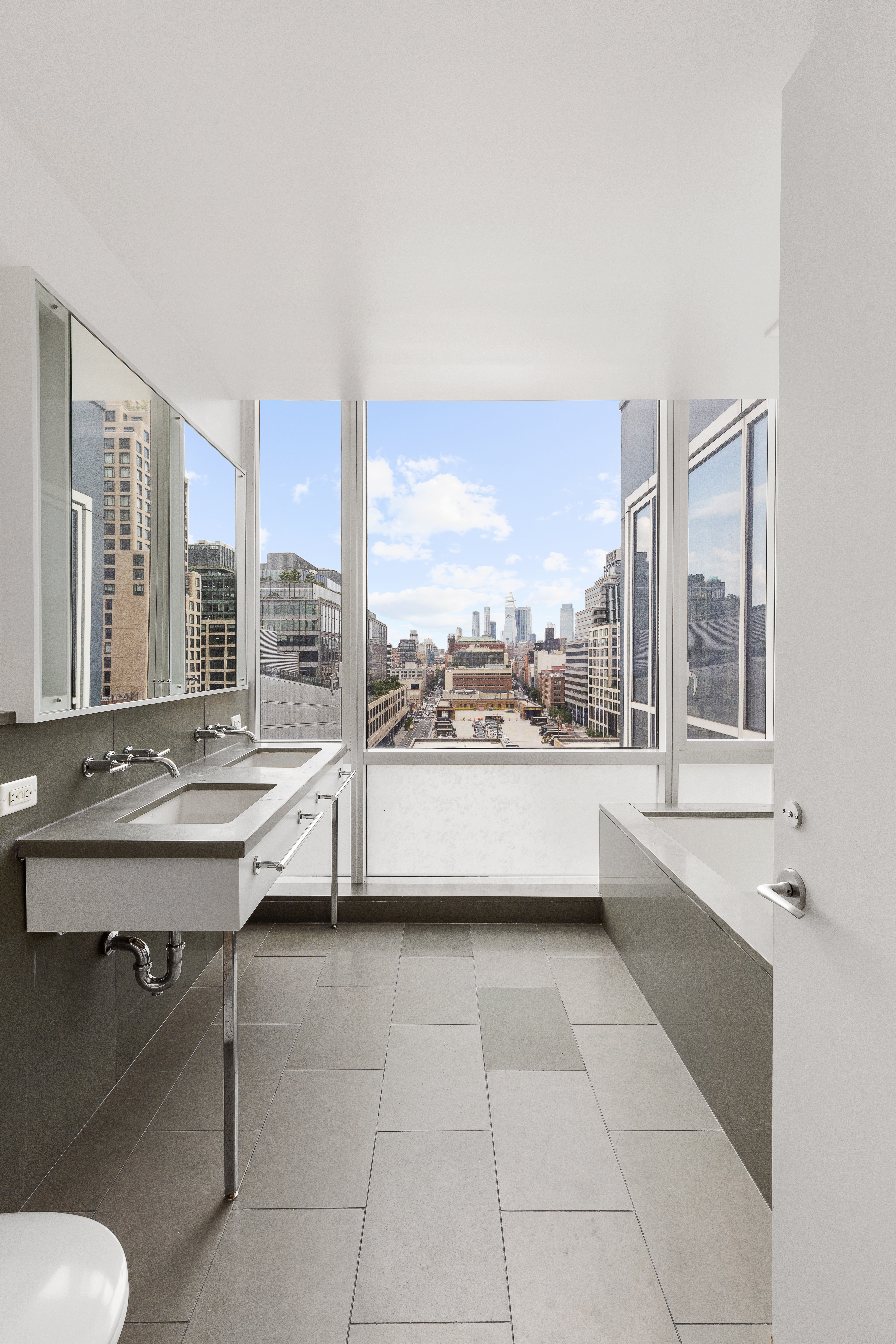 330 Spring Street, Unit 11B Manhattan, NY 10013 - Photo 8 of 10 a bathroom with a tub sink and mirror