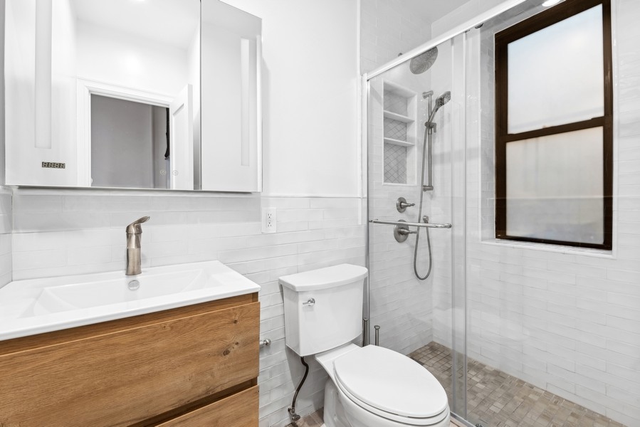 208 East 90th Street, Unit 2W Manhattan, NY 10128 - Photo 7 of 10 a bathroom with a sink a toilet and shower