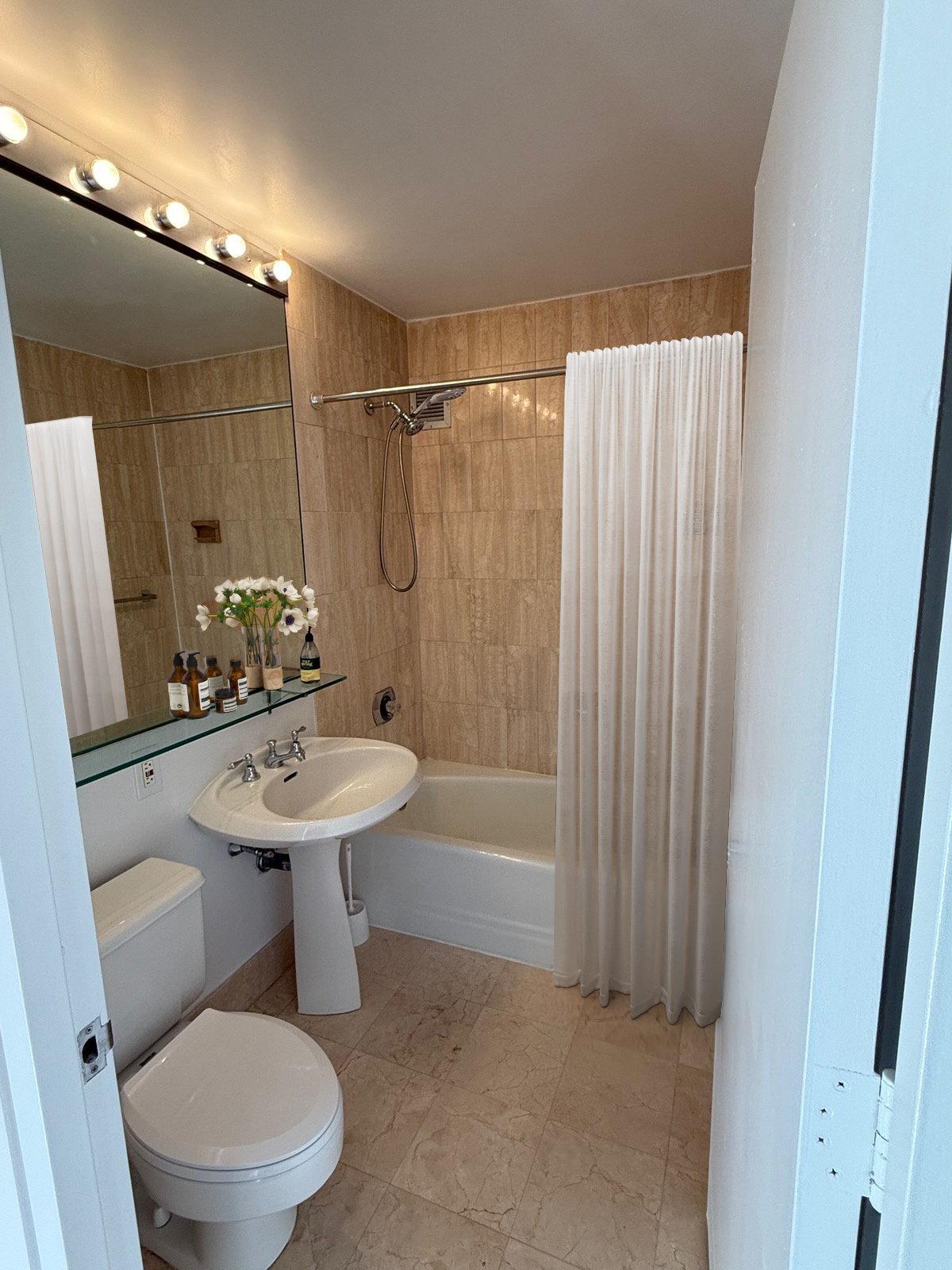 45 West 67th Street, Unit 21C Manhattan, NY 10023 - Photo 8 of 10 a bathroom with a sink a toilet a mirror and shower