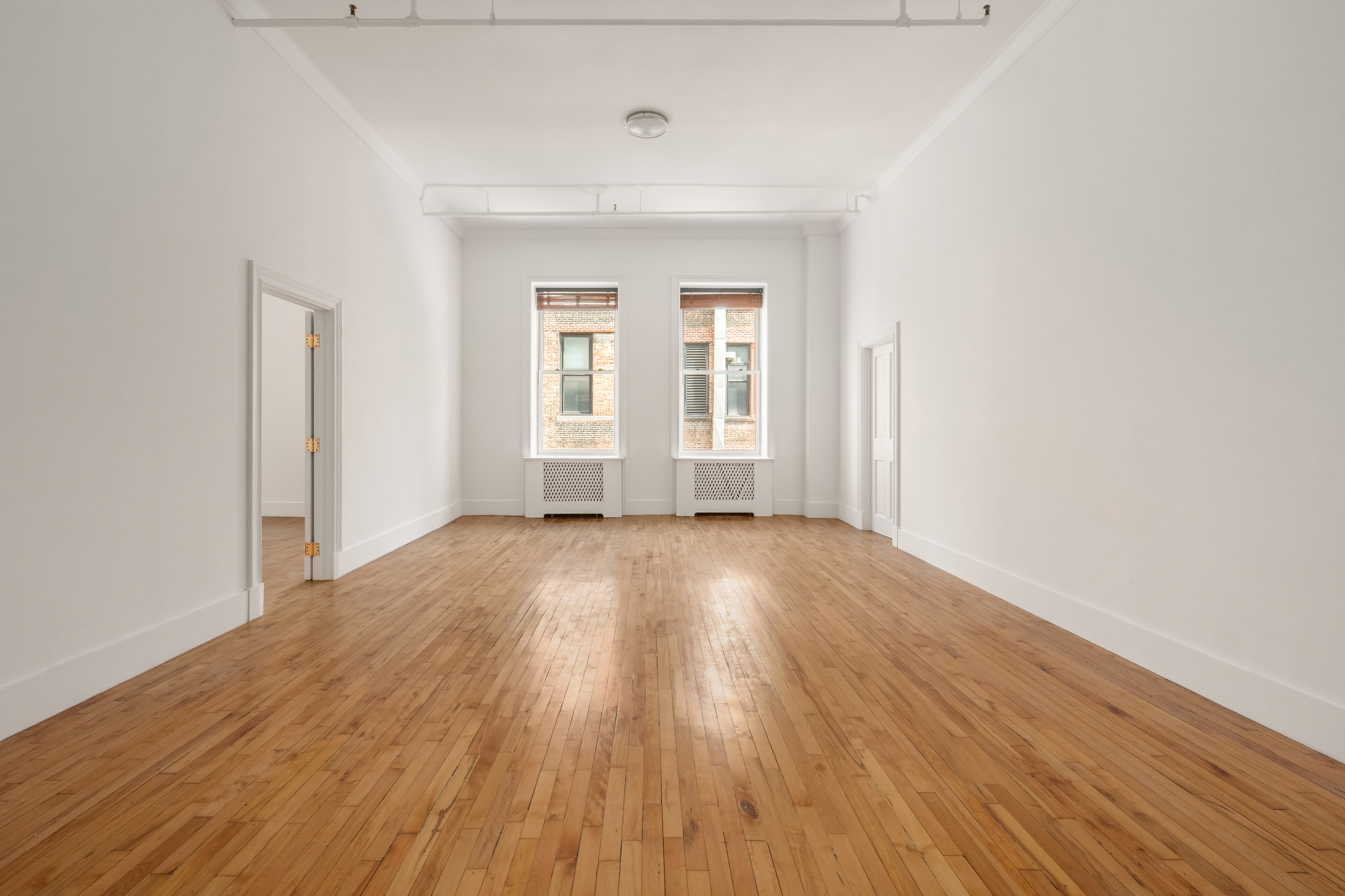 519 Broadway, Unit PHC Manhattan, NY 10012 - Photo 8 of 16 an empty room with wooden floor and windows