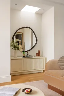 a living room with a bed furniture and a mirror