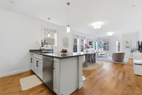 a kitchen with counter top space and wooden floor