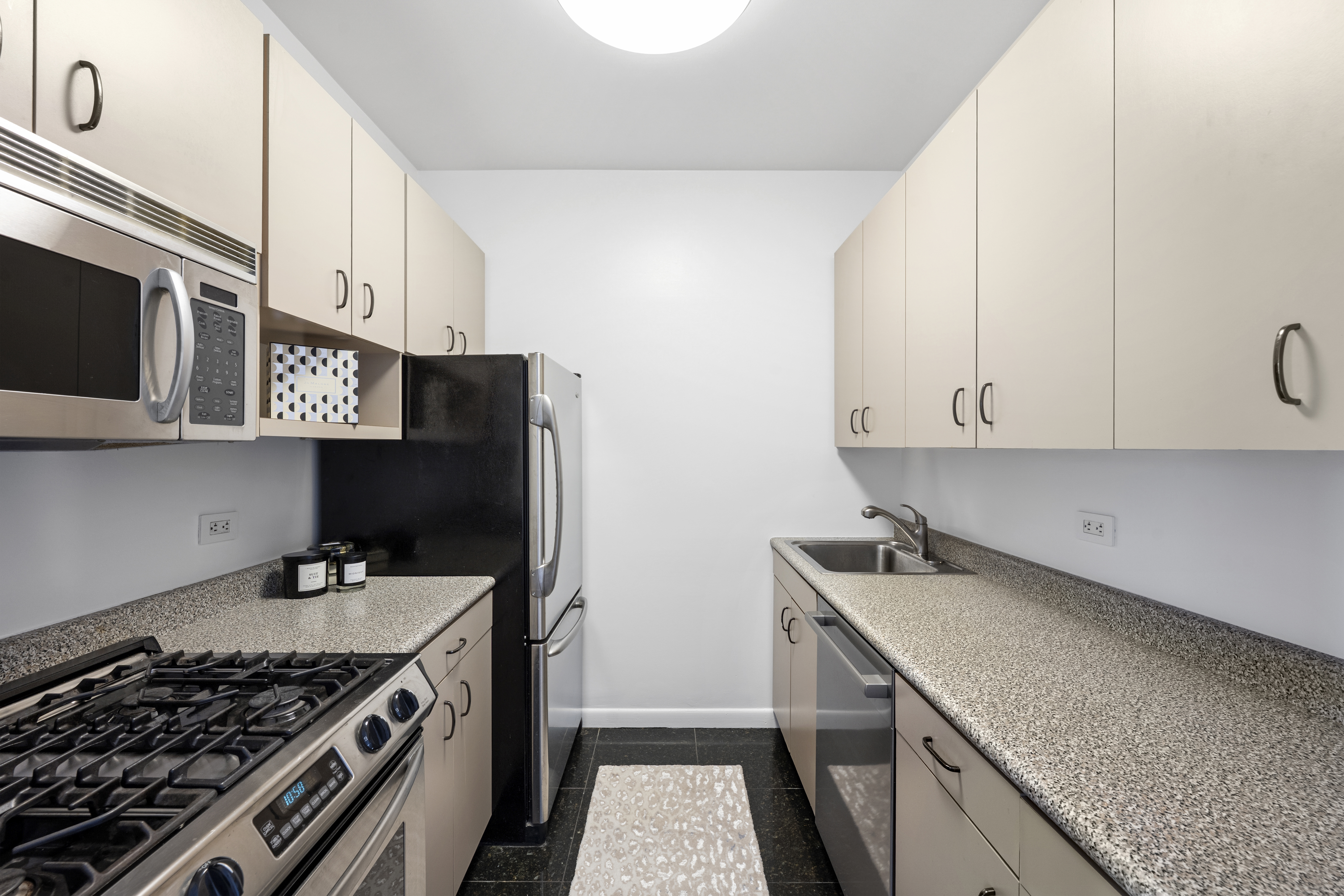 111 West 67th Street, Unit 22B Manhattan, NY 10023 - Photo 8 of 10 a kitchen with stainless steel appliances granite countertop a stove and a sink