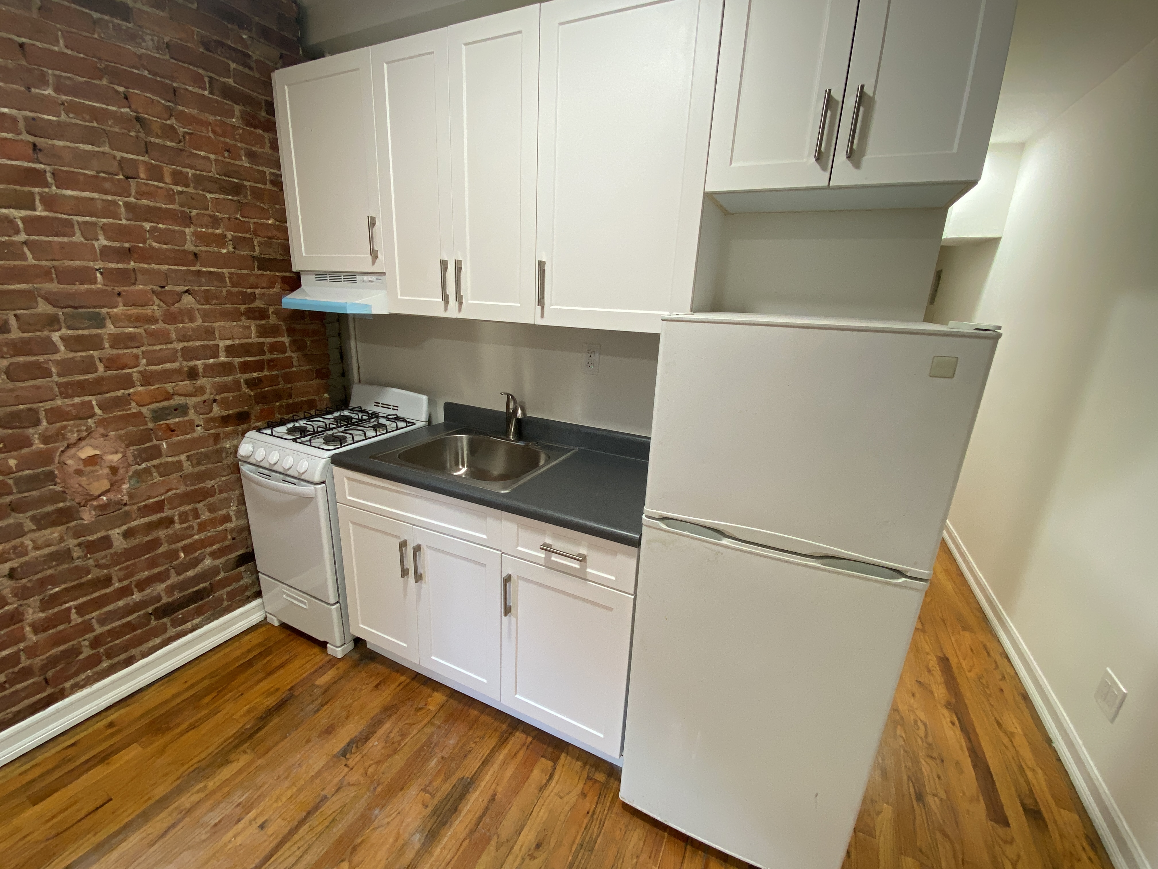 435 East 75th Street, Unit 10 Manhattan, NY 10021 - Photo 2 of 6 a kitchen with a sink and cabinets