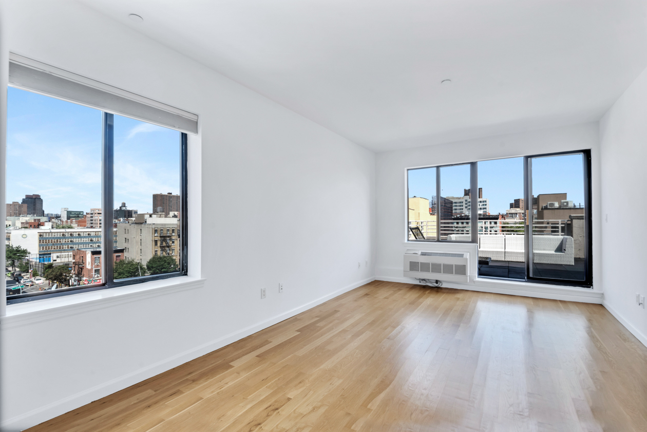 416 East 117th Street, Unit PH6 Manhattan, NY 10035 - Photo 5 of 20 a view of a kitchen with wooden floor and electronic appliances