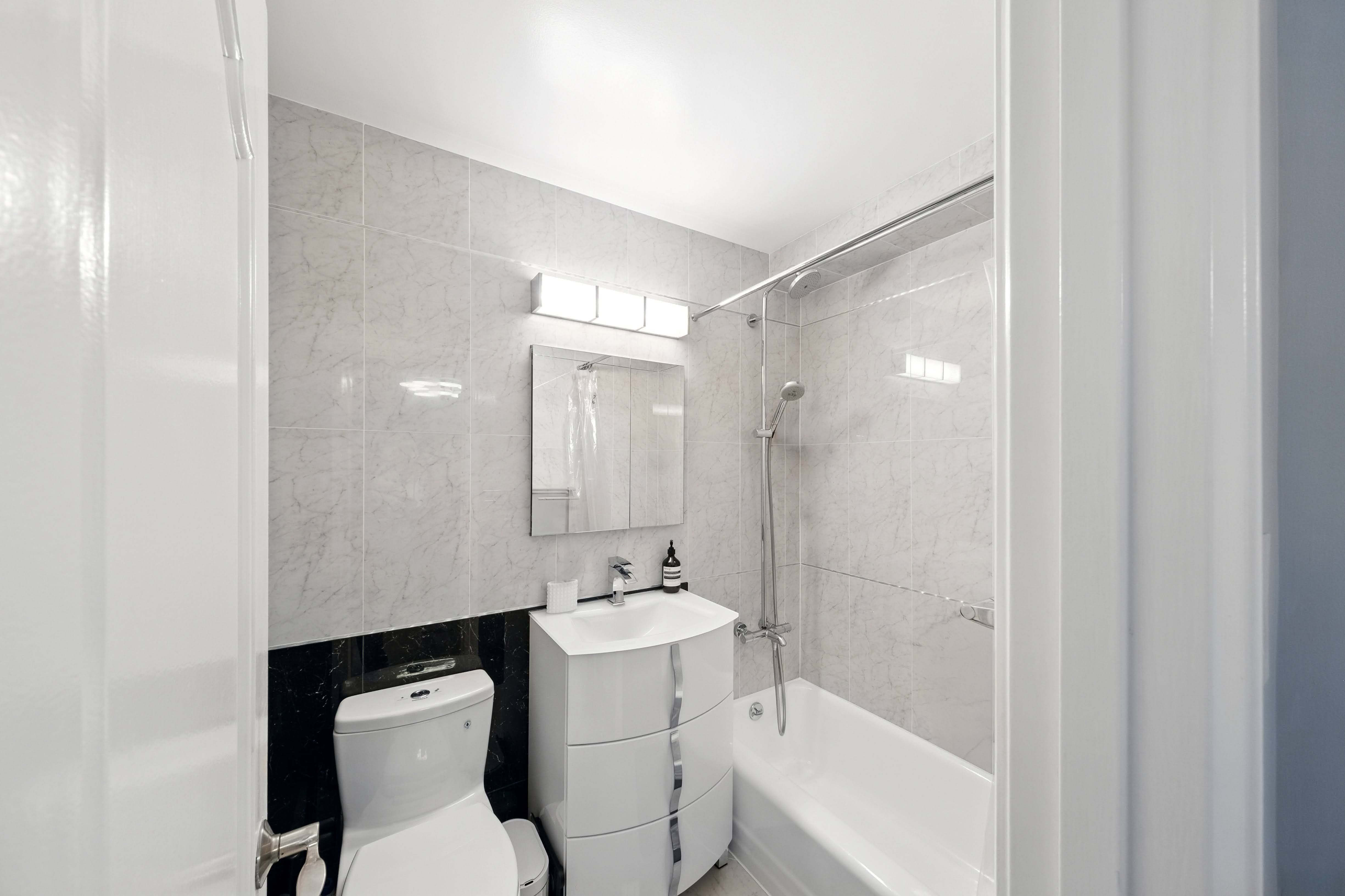 1360 Ocean Parkway, Unit 7B Brooklyn, NY 11230 - Photo 7 of 14 a bathroom with a bathtub shower sink mirror and toilet