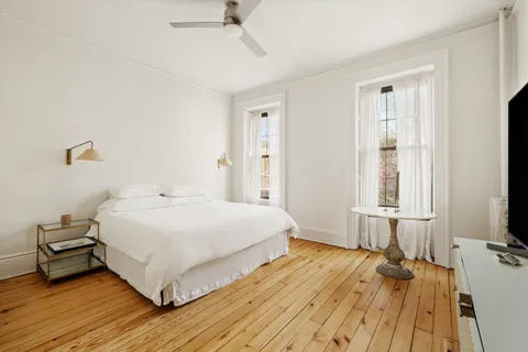 a bedroom with a bed and a large window