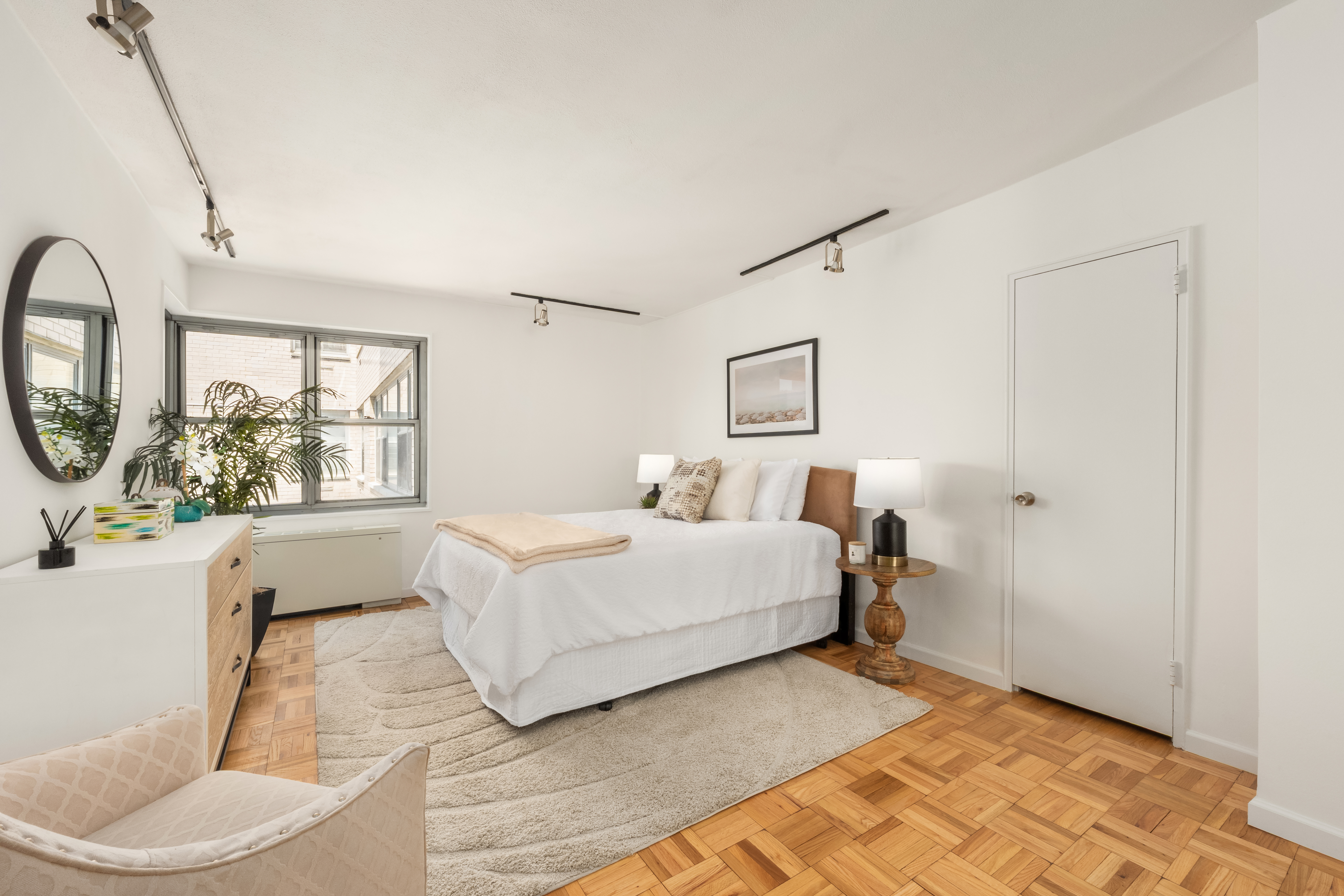400 East 56th Street, Unit 38S Manhattan, NY 10022 - Photo 10 of 16 a spacious bedroom with a bed a mirror and a large window