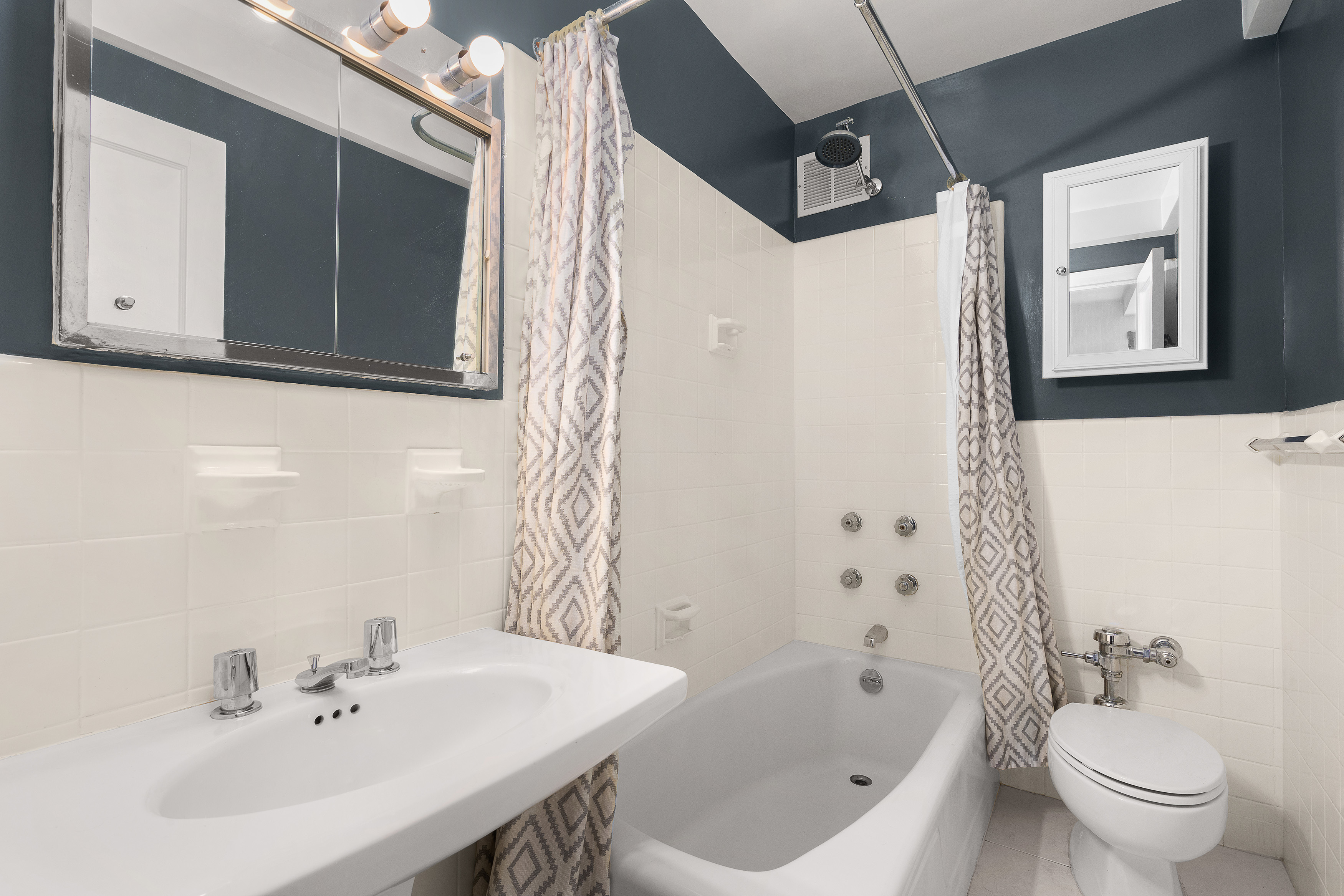 400 East 52nd Street, Unit 7A Manhattan, NY 10022 - Photo 6 of 9 a bathroom with a sink a toilet and shower