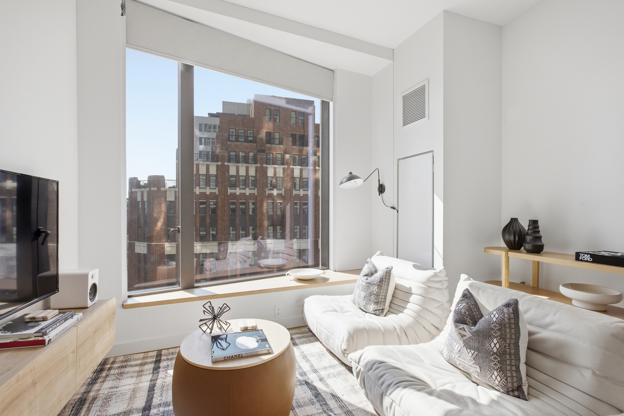 11 Hoyt Street, Unit 14M Brooklyn, NY 11201 - Photo 2 of 22 a living room with furniture a flat screen tv and a floor to ceiling window