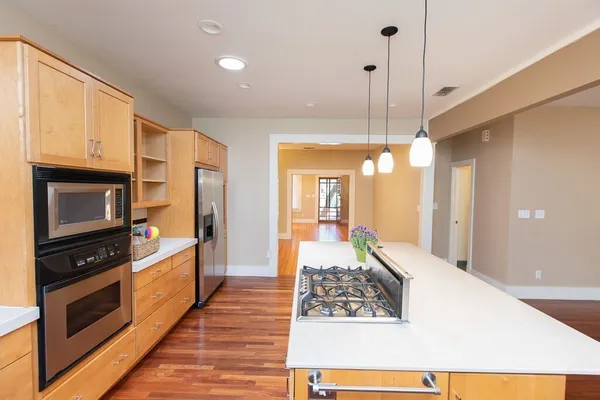 a open kitchen with stainless steel appliances granite countertop a stove a sink and a refrigerator