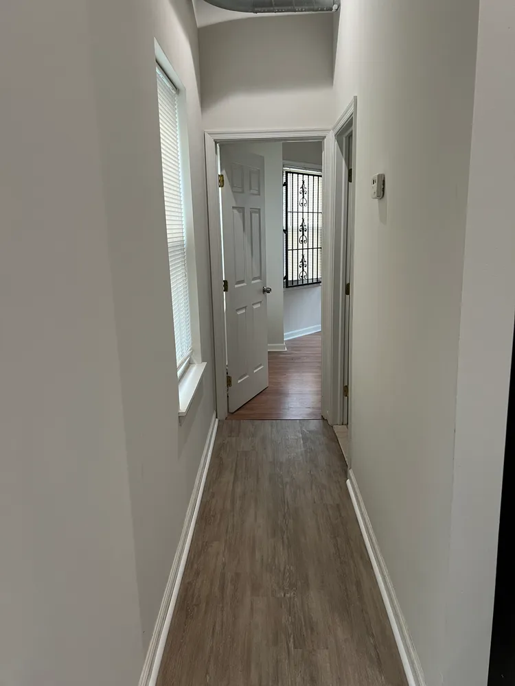 a view of a hallway with wooden floor
