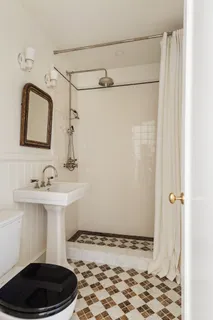 a living room with furniture a large window and wooden floor