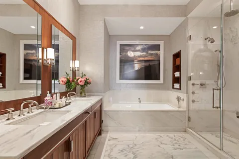 a bathroom with a tub sink and mirror