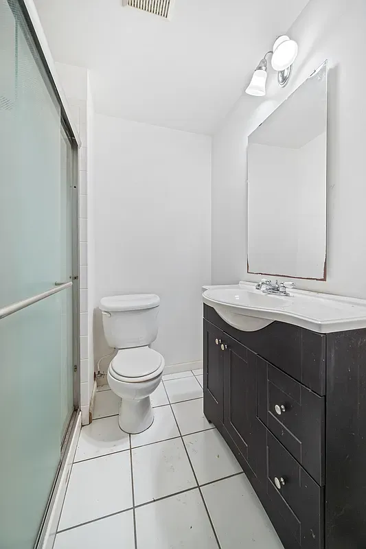 a bathroom with a granite countertop toilet sink and mirror