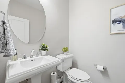 a bathroom with a sink mirror and toilet