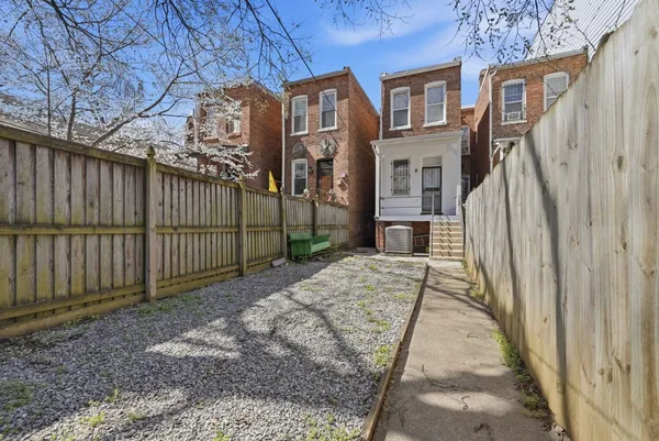a view of a brick house with wooden fence