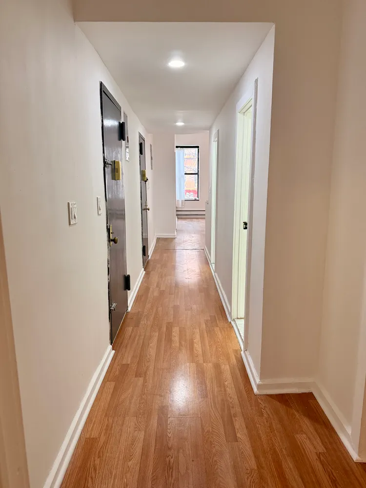 a view of a hallway with wooden floor