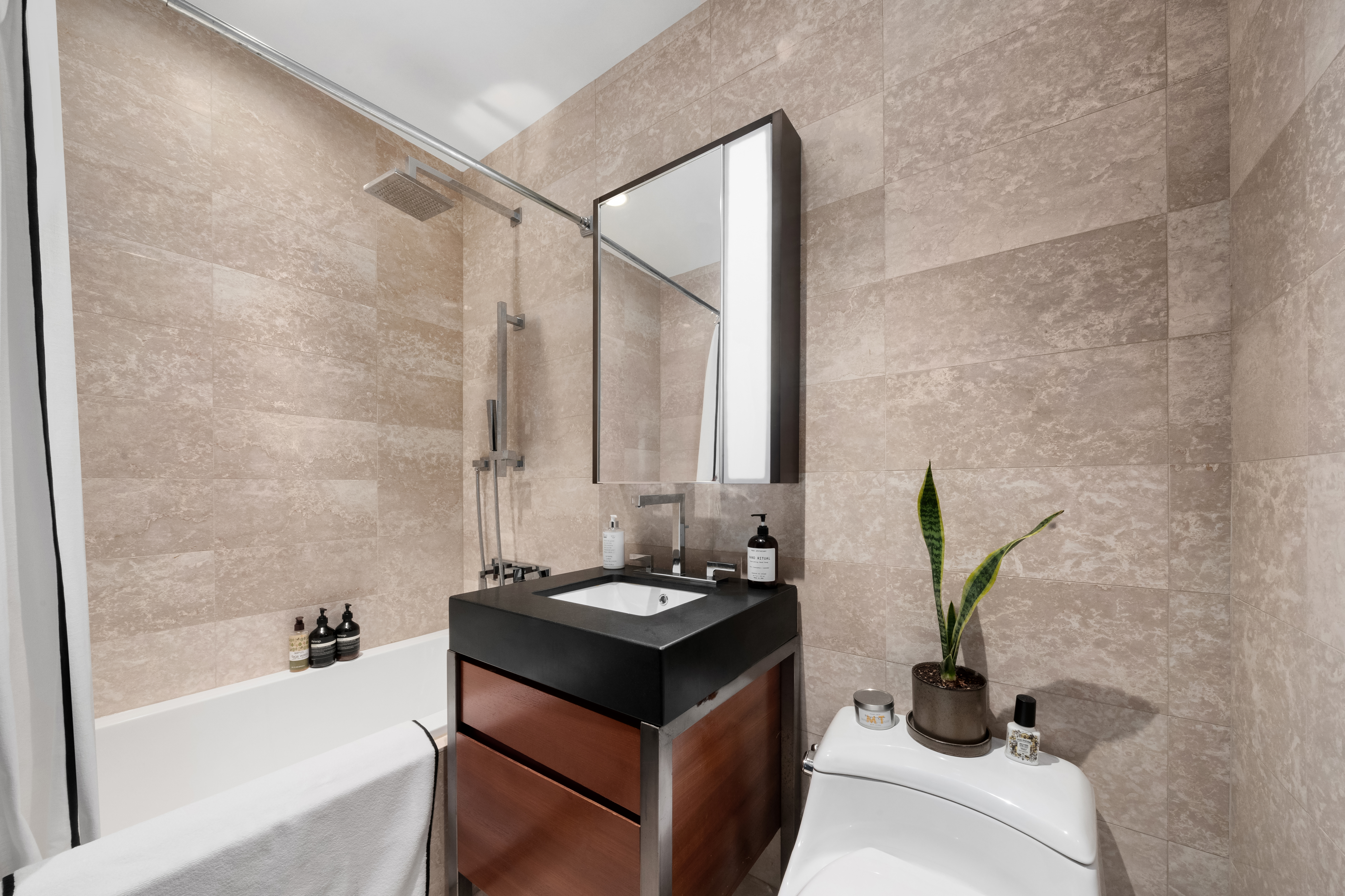 75 Wall Street, Unit 22O Manhattan, NY 10005 - Photo 10 of 11 a bathroom with a bathtub and a sink