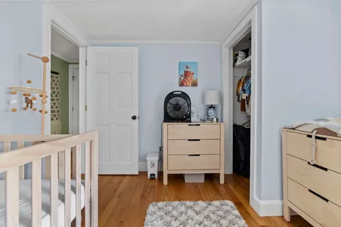 a bedroom with a baby bed baby crib and a dresser