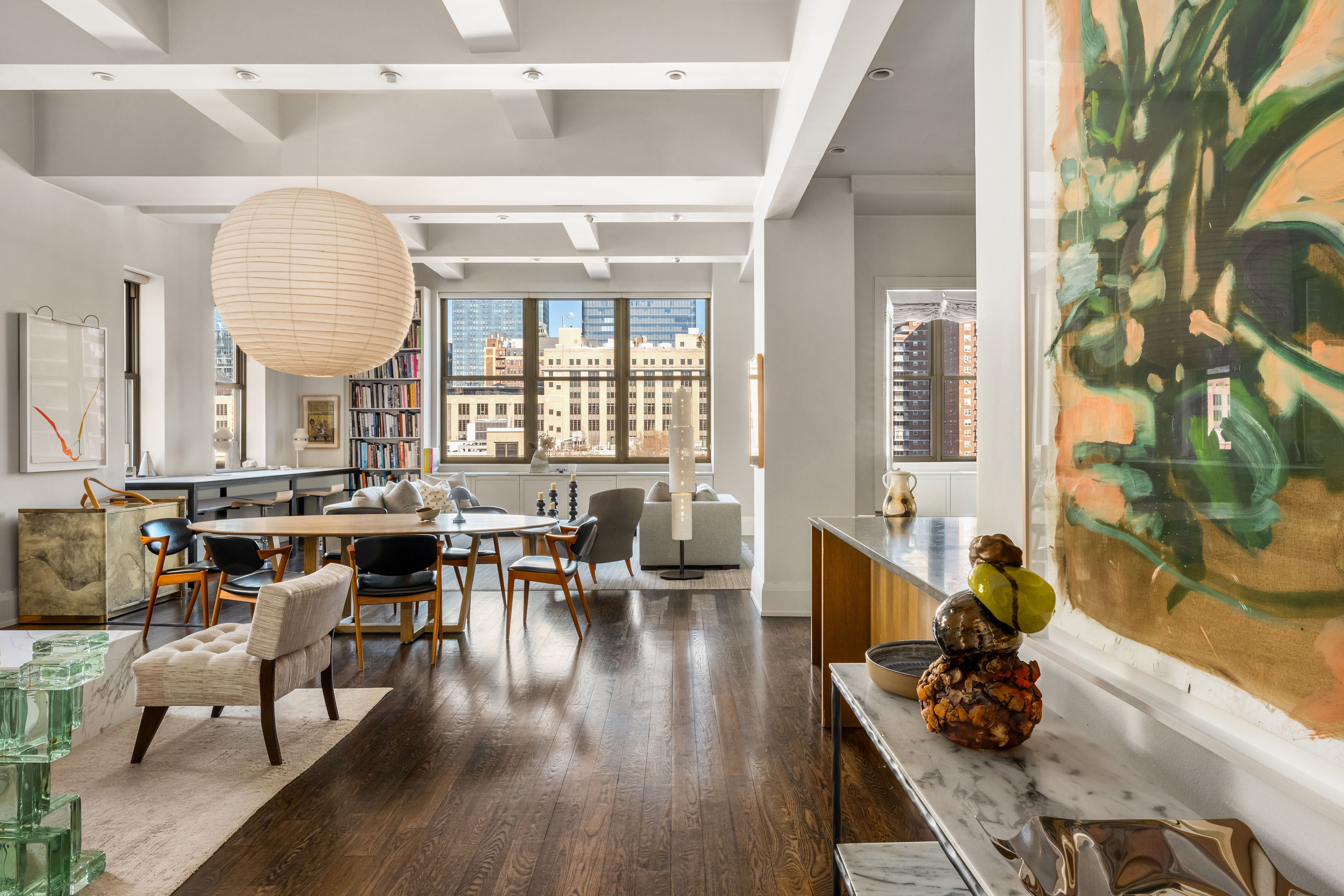 a dining room with wooden floor and large windows