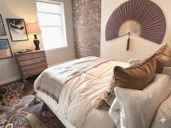 a bedroom with a bed and wooden floor