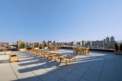 a view of a terrace with lawn chairs and a barbeque