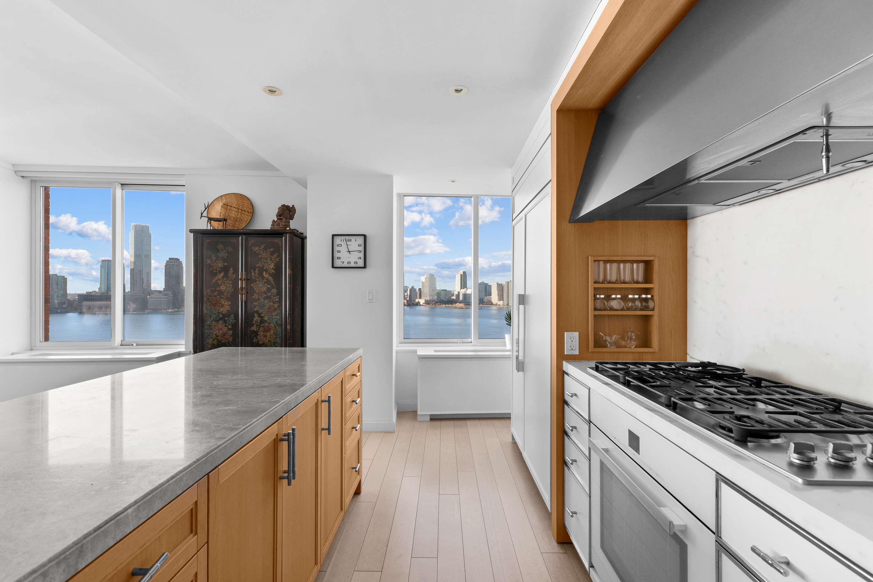 212 Warren Street, Unit 20A Manhattan, NY 10282 - Photo 7 of 23 a kitchen with refrigerator and wooden cabinets