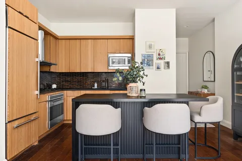 a kitchen with sink cabinets dining table and chairs