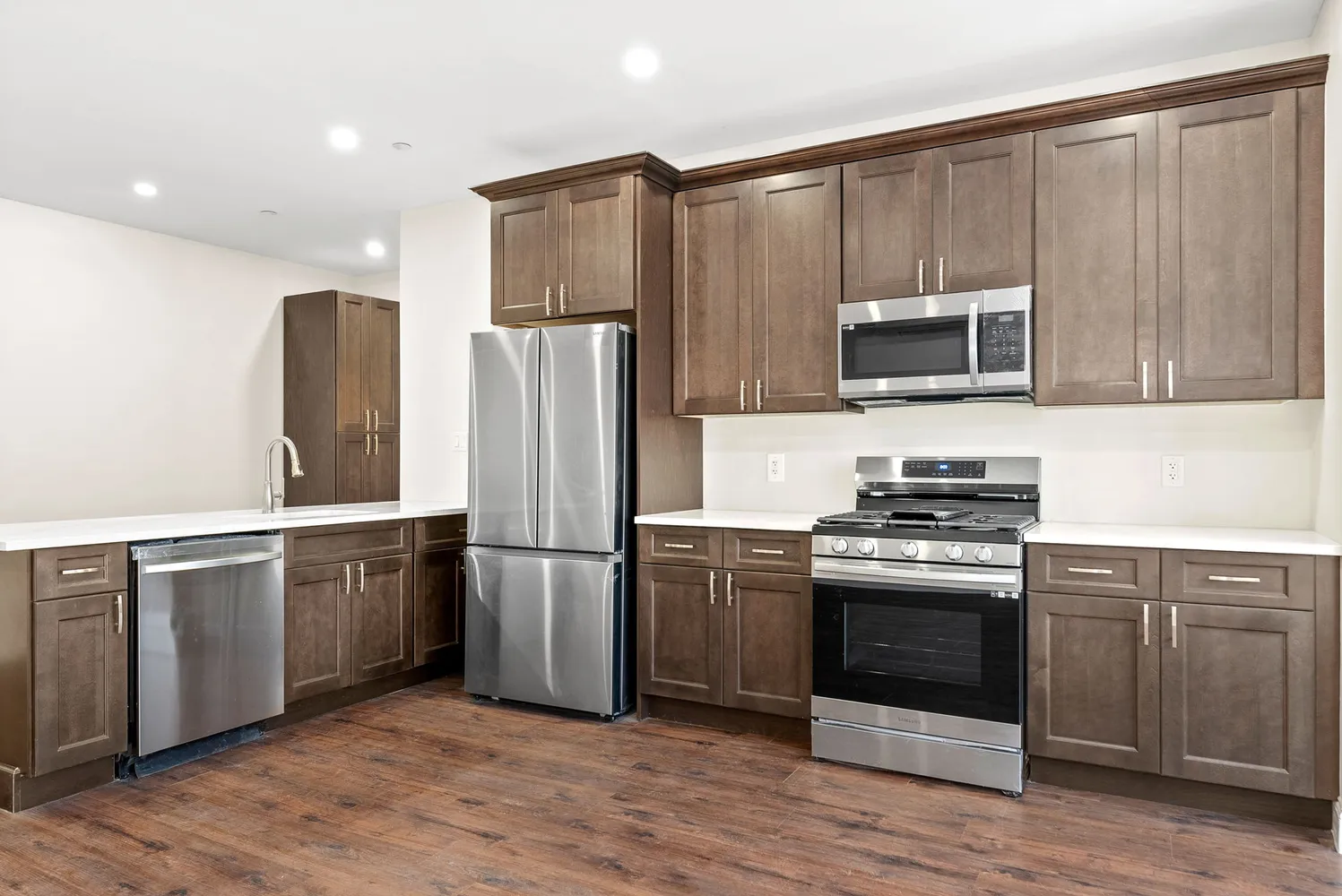 a kitchen with stainless steel appliances a stove a sink and a microwave