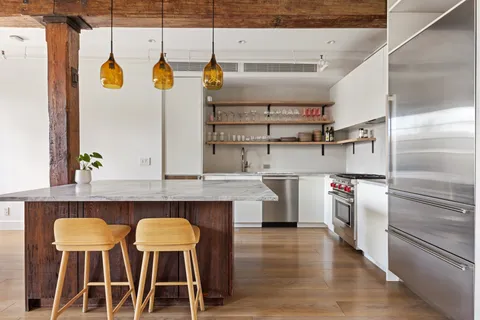 a kitchen with stainless steel appliances a stove a refrigerator and cabinets