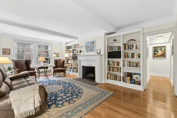 a living room with furniture large window and a fireplace