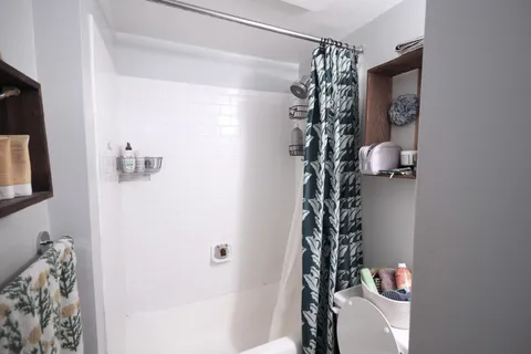 a bathroom with a shower curtain and a toilet