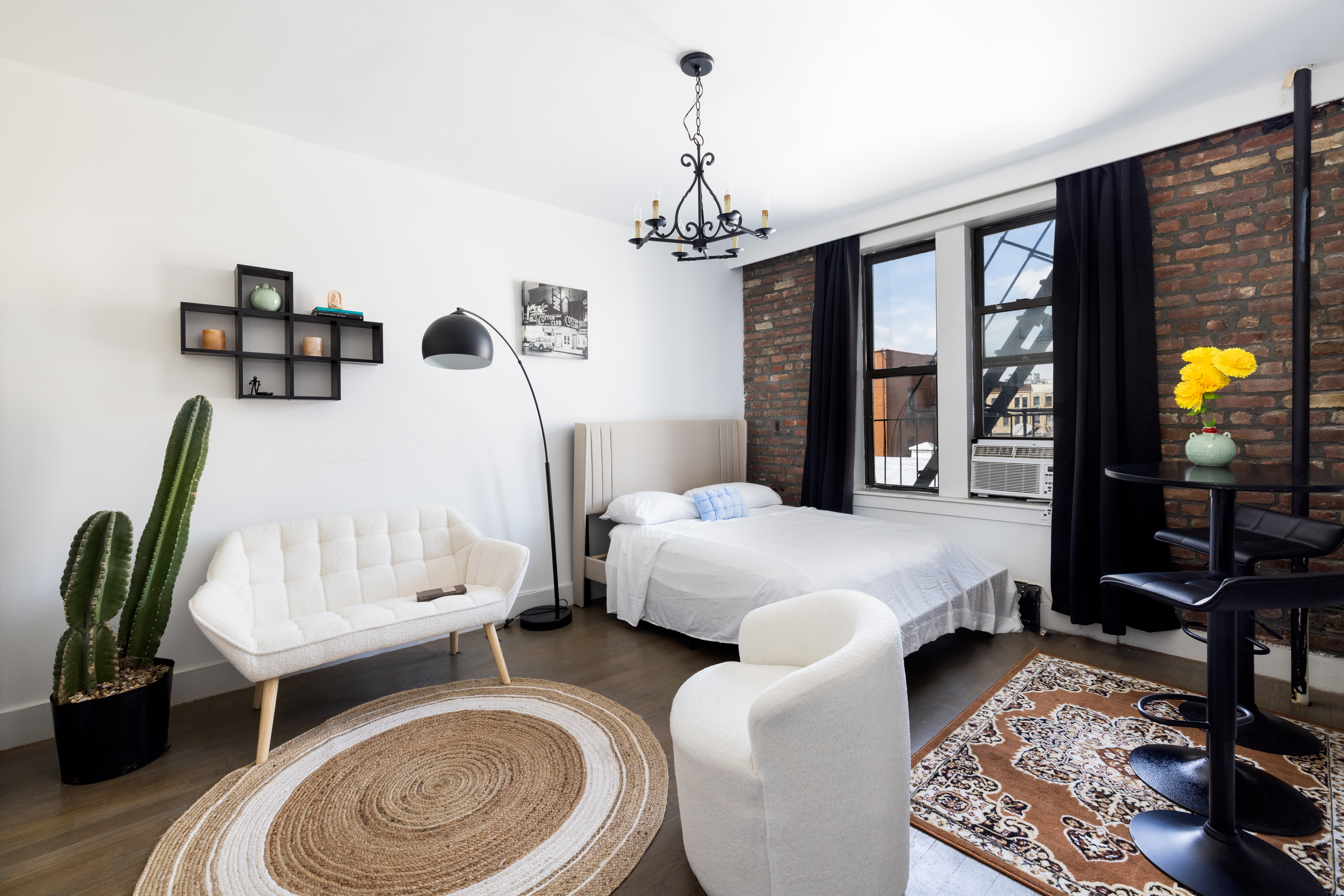 48 West 138th Street, Unit 5J Manhattan, NY 10037 - Photo 2 of 13 a bed room with furniture and a chandelier