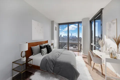 a bedroom with a bed and a large window