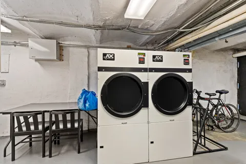 a utility room with dryer washer and stair