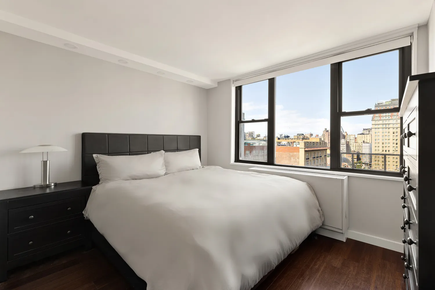 a large bed sitting in a bedroom next to a window