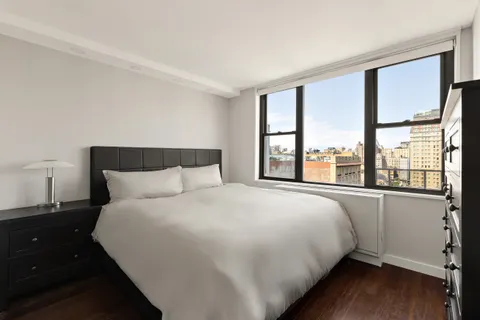 a large bed sitting in a bedroom next to a window