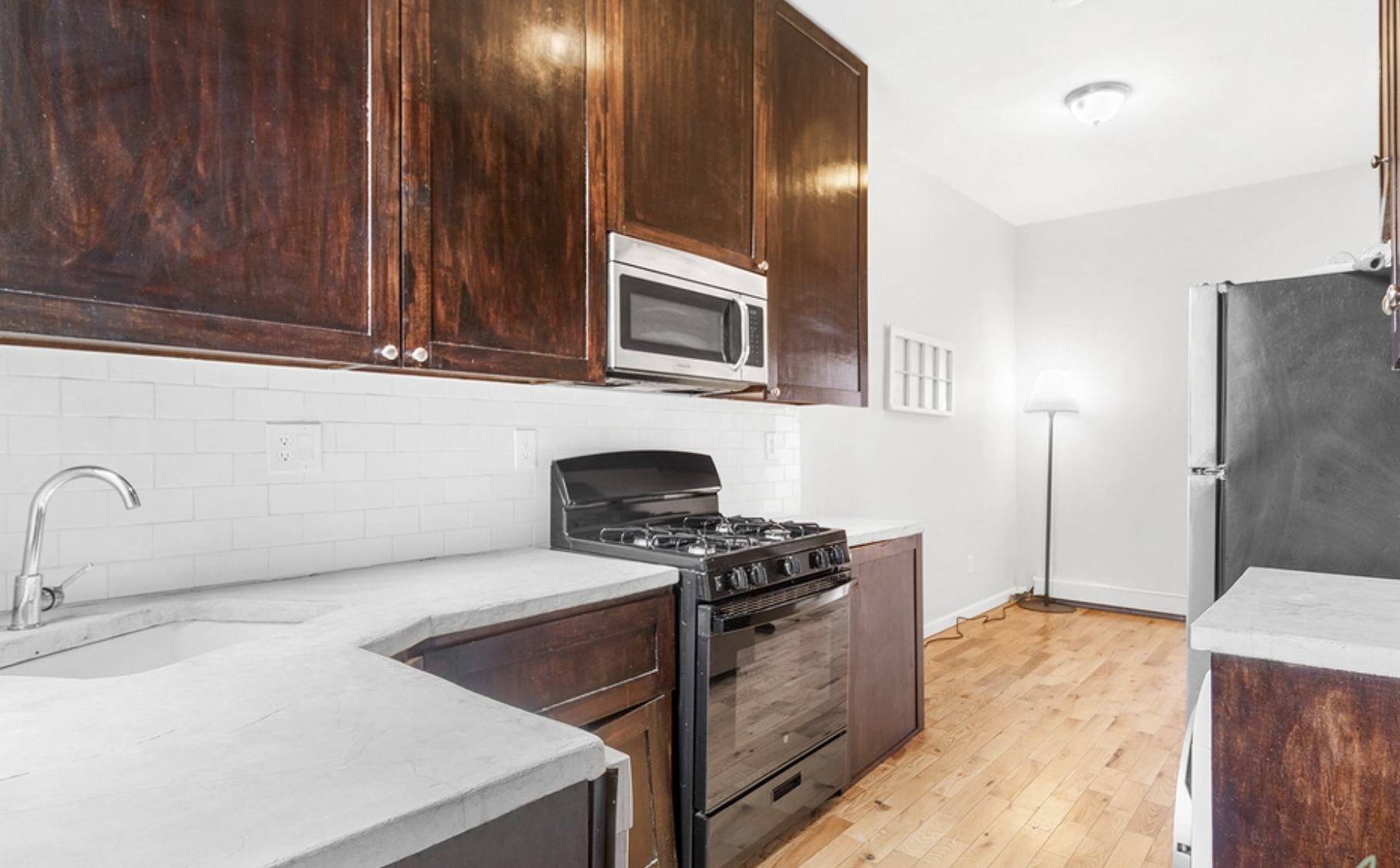 22-18 41st Street, Unit 2R Queens, NY 11105 - Photo 4 of 10 a kitchen with stainless steel appliances granite countertop a stove a sink and a microwave