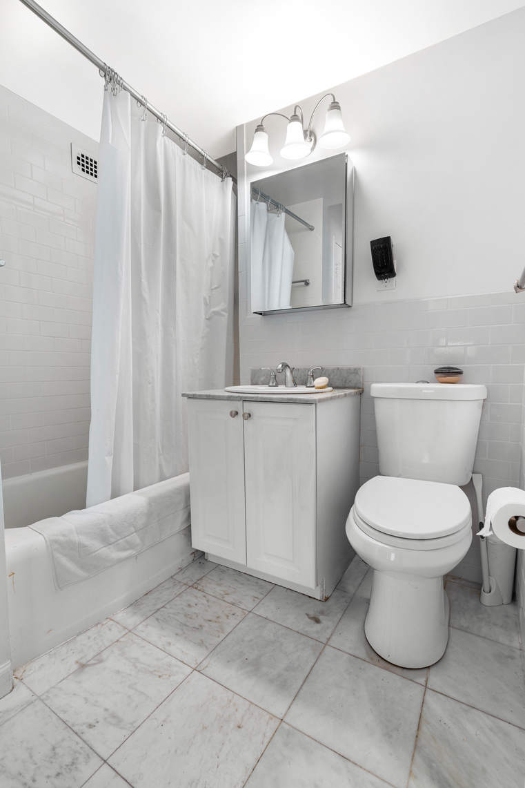 305 East 72nd Street, Unit 13I Manhattan, NY 10021 - Photo 8 of 14 a bathroom with a toilet sink and mirror